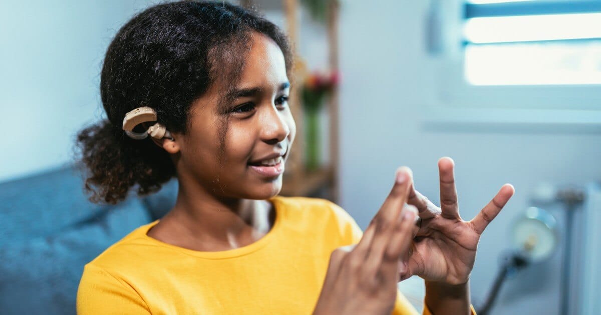 Here we have a young person, sporting her hearing aid like a badge of honor, harnessing the power within herself through expressive hand gestures. She's saying no to limitations imposed by her hearing challenges and yes to empowerment. Defining herself not by her condition but through self-belief, she steps boldly into a world where potential is limitless for those who dare to pursue it. This is the spirit that fuels our foundation: promoting understanding, respect, and inclusion for hard of hearing youth as they unlock their true potential in their journey towards achieving extraordinary things!
