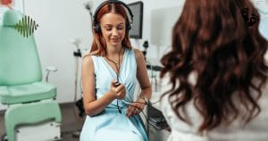 A young woman undergoing a hearing test with headphones in a clinical setting.