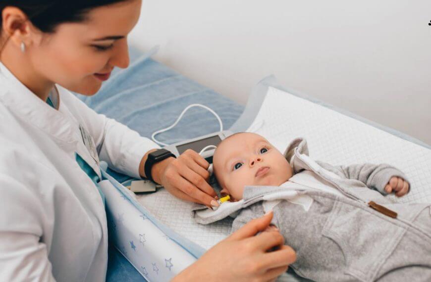 Pediatrician performing a hearing screening on a newborn baby.