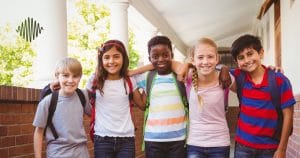 Imagine five kids, backpacks slung over their shoulders, united in a sunlit corridor. Their smiles say it all - at "aac-for-hoh-children," we build more than just communication skills; we cultivate community and uplift HOH youth together. This is where friendships form and confidence grows, all while fostering an inclusive and supportive environment.