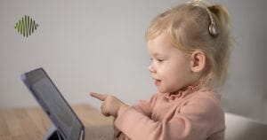 Picture a young child in a vibrant pink top, completely engrossed in their learning tablet. With the power of a cochlear implant we are opening worlds of opportunity for hard of hearing youth. Together, let's amplify their potential and transform challenges into triumphs.