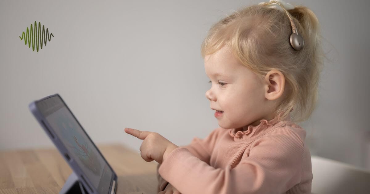 Picture a young child in a vibrant pink top, completely engrossed in their learning tablet. With the power of a cochlear implant we are opening worlds of opportunity for hard of hearing youth. Together, let's amplify their potential and transform challenges into triumphs.