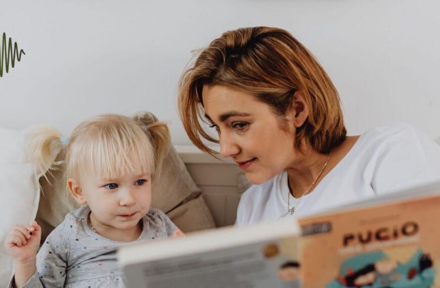 Imagine a cozy scene: a mother with chic short hair learened into a speech therapy book, sharing insights with her blonde, pigtailed daughter nestled on the bed. A signature green logo with wavy lines graces the top left corner, symbolizing our foundation’s dedication to empowering hard of hearing youth through engaging and supportive learning.